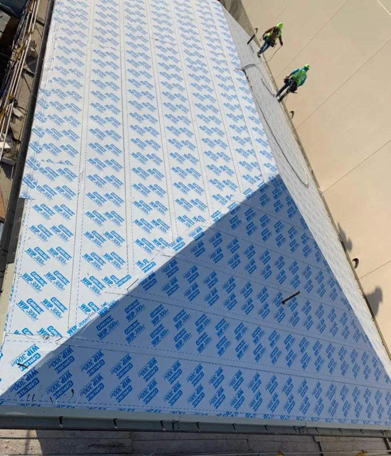 Professional roofers installing underlayment on a metal roof in Denville